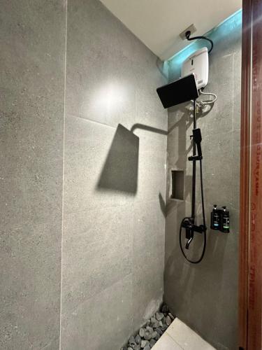 baño con ducha con una cámara en la pared en Calathea Suites El Nido, en El Nido
