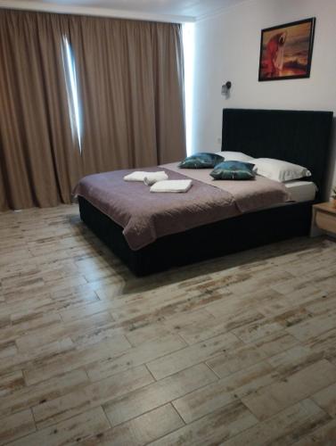 ein Schlafzimmer mit einem Bett und einem Holzboden in der Unterkunft Studio apartament in Craiova