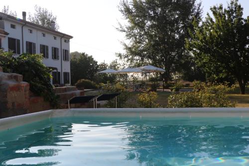 a swimming pool in front of a house at Agriturismo Viridarium in Castellucchio