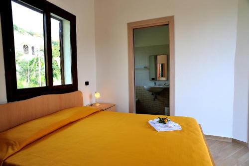 a bedroom with a large yellow bed with a window at Santa Maria in Cittadella del Capo