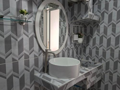 a bathroom with a white sink and a mirror at Suwita House in Nai Yang Beach