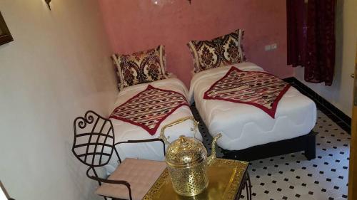 a small room with two beds and a table at Dar Nour Fes - Luxury lodging in Fès