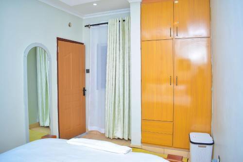 a bedroom with a bed and a large wooden cabinet at DeeHomes in Eldoret