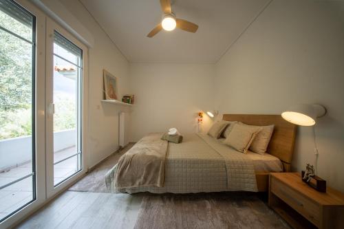 a bedroom with a bed and a large window at Olive Grove Retreat in Mytilini
