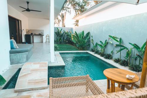 a swimming pool in a backyard with a table and chairs at Villa Dot -Beach Front and private pool villa in Gili Air