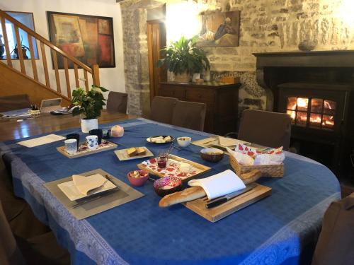 a table with a blue table cloth with food on it at Les Eaux Calmes in Talcy