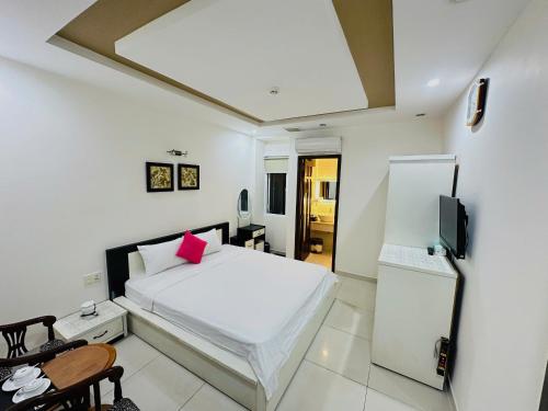 a bedroom with a white bed and a television at 3Z Hotel - Zephyr Zen Zone in Hanoi