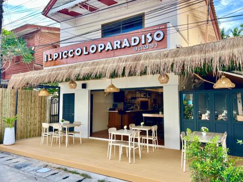 a restaurant with tables and chairs on a wooden deck at Il Piccolo Paradiso - Hôtel in Koh Samui