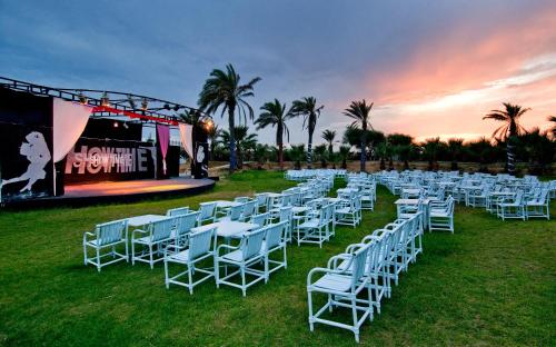 a group of white tables and chairs in front of a stage at Royal Thalassa Monastir in Monastir