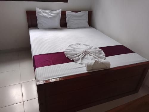 a bed with white sheets and a blanket at Golden Heavens kengalla in Kandy