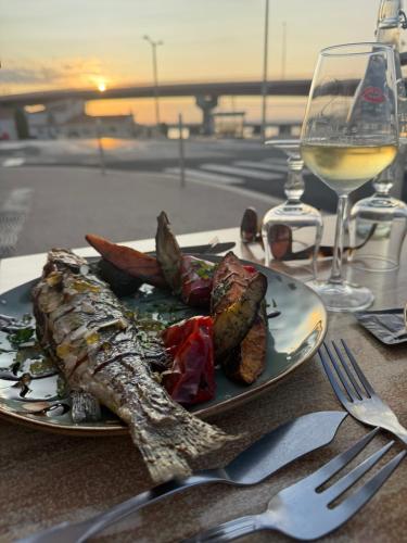 a plate of food on a table with a glass of wine at Authentic fisherman's house Maison de pêcheur authentique in Port-la-Nouvelle