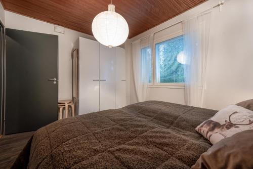 Un dormitorio con una cama grande y una ventana en Aurinkorinne1 - Skistar spacious apartment with sauna, en Syöte