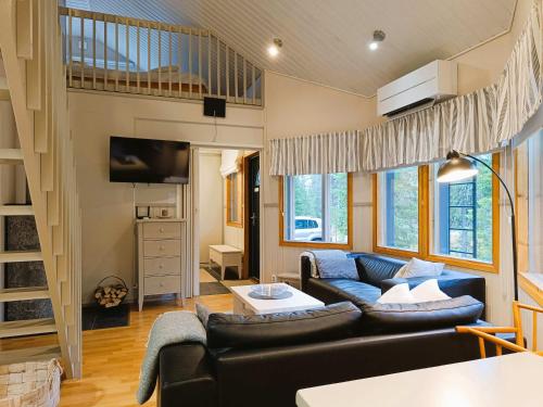 Una sala de estar con un sofá y un loft. en Tupasvilla, en Syöte