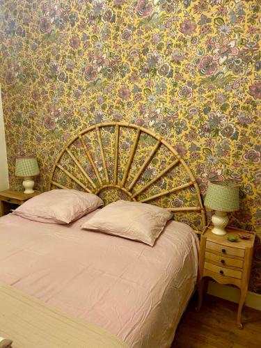 a bedroom with a large bed with a floral wallpaper at Maison Les Planches Trouville in Trouville-sur-Mer