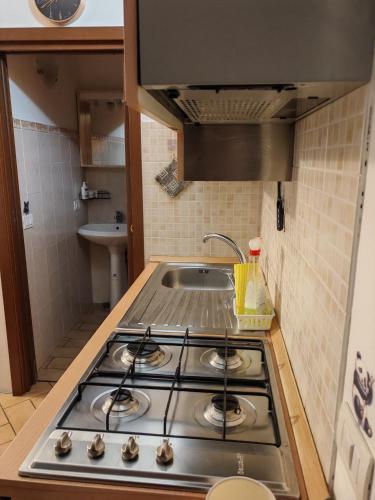 a stove top in a kitchen with a sink at Casa MINO PARMA in Correggio