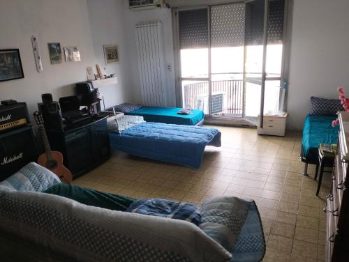 sala de estar con sofás azules y balcón en Camere Artisti Musicisti Viaggiatori Vacanze, en Verona