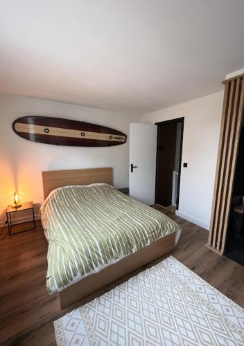 a bedroom with a bed with a surfboard on the wall at Le Duplex de la côte in Dinard