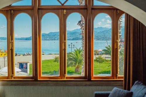 a window with a view of a beach and the water at Hotel Neon in Batumi