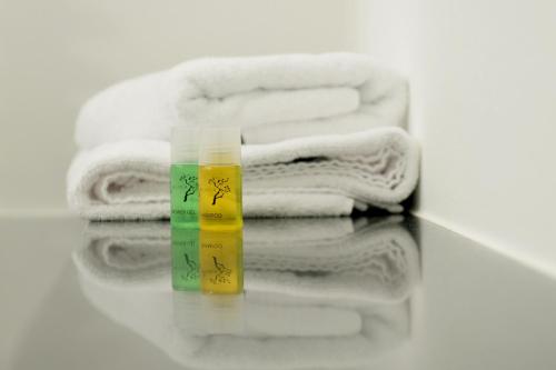 a group of towels and a bottle ofitizerness at HOMEFY - Gasthaus Düsseldorf - Meerbusch in Meerbusch