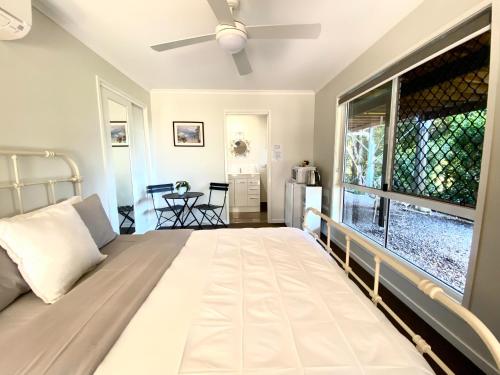 a bedroom with a large bed and a large window at Mandys at Maleny in Maleny