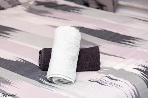 a roll of toilet paper sitting on top of a bed at Ubuntu House - Charleroi in Charleroi