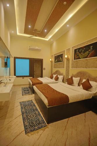 a hotel room with two beds and a television at Hotel Om Vilas in Jait