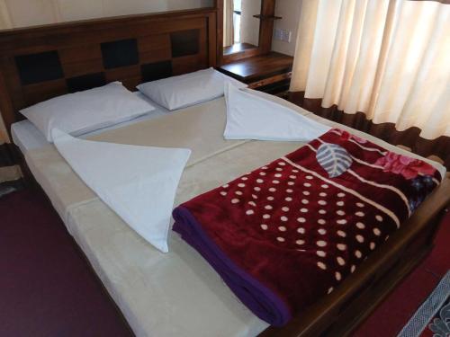 - un lit avec des draps blancs et une couverture rouge dans l'établissement Villa Friendly Faces, à Nuwara Eliya