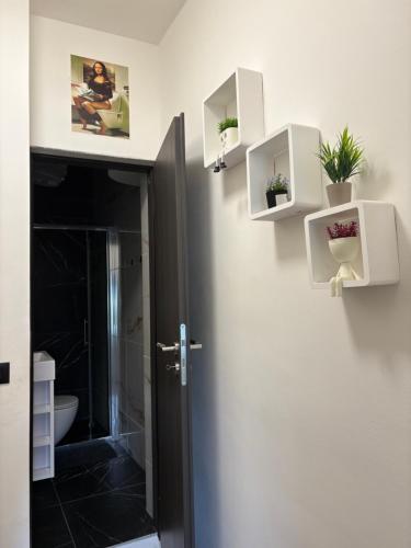 a bathroom with a toilet and some plants on the wall at Banija studio apartments in Karlovac