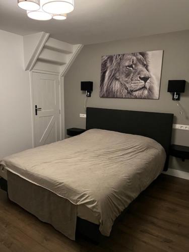 a bedroom with a bed with a lion picture on the wall at De Gouwe Leeuw in Woerdense Verlaat