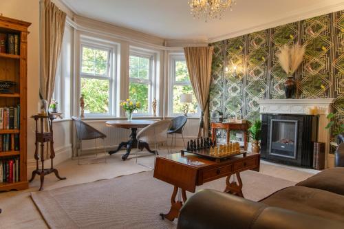 a living room with a fireplace and a table at The Cherry Tree B&B in Eastbourne