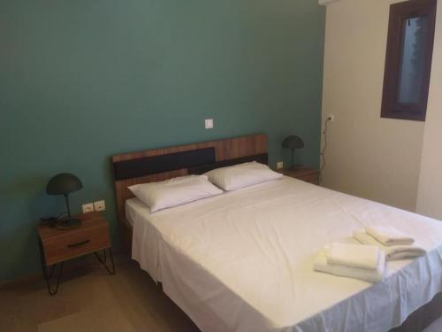 a bedroom with a white bed with towels on it at Stylianos House 6 in Leonidion