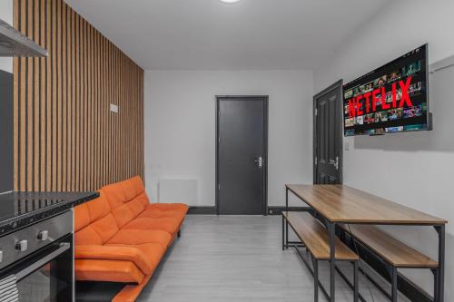 un salon avec un canapé orange et une table dans l'établissement Sheaf 2 Sheldon 2BR Stay Sleeps 4 & Superfast Wi-Fi, à Sheldon