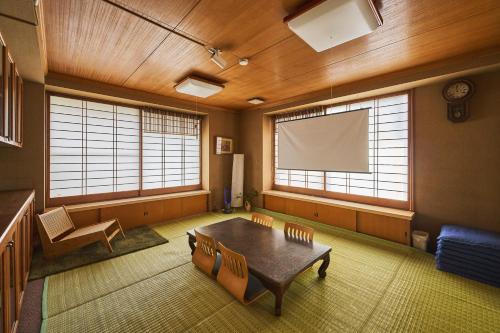 a large room with a table and a screen at Traditional Japanese House, MtFuji view ,Free bag ,4 bedrooms ,Rent bike in Fujiyoshida