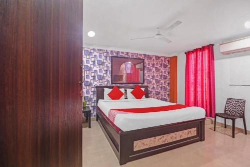 Un dormitorio con una cama y una cortina roja. en Hotel O New Lakeview Palace, en Hyderabad