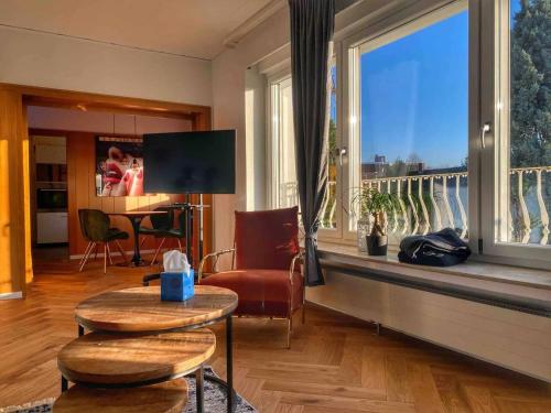 Una sala de estar con un gran ventanal con vistas. en Thomas Edison - Wohnung mit großer überd. Terrasse, en Wesel
