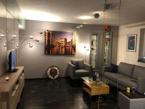 a living room with a couch and a tv at Cocktailpedia - Apartment mit Loggia in Wesel