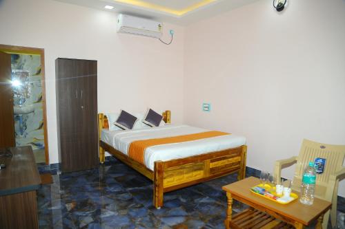 une chambre avec un lit et une table dans l'établissement Seawave Beach Resort, à Bahūr