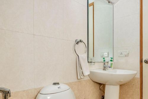 un bagno con lavandino, WC e specchio di Tea Pavilion a Bangalore