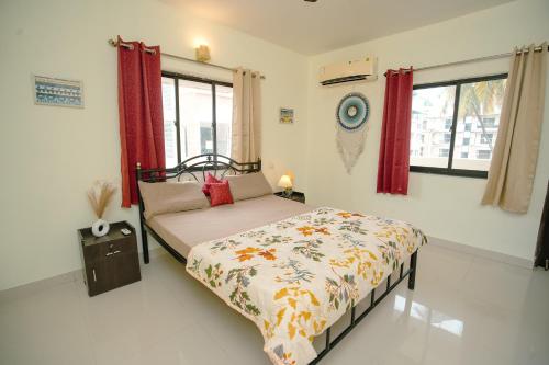 een slaapkamer met een bed en rode gordijnen bij Sukoon by Second Homes in Candolim