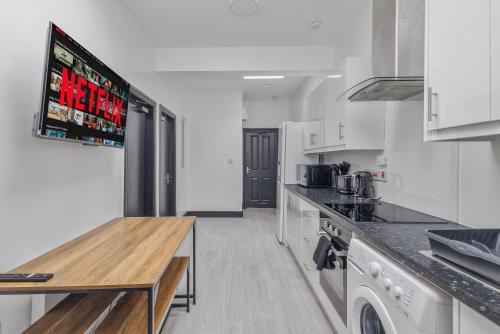 SheldonにあるStylish 2BR Apartment in Sheldonの白いキッチン(木製テーブル付)