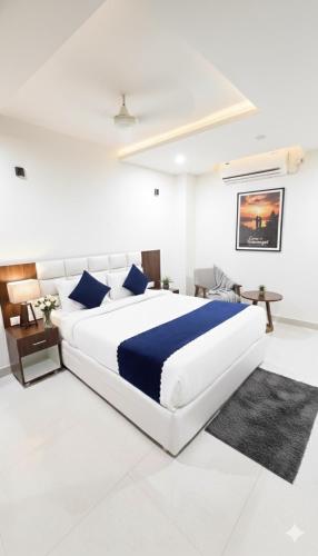 a white bedroom with a large bed and a desk at Hotel SkyLand Warangal in Warangal