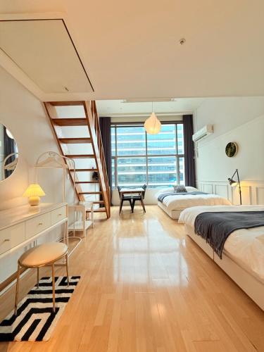 a bedroom with a bed and a staircase at Miumi Duplex House Hong Dae in Seoul