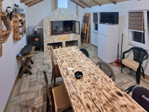 ein großer Holztisch in einem Raum mit Kamin in der Unterkunft Apartman Ana in Kupres