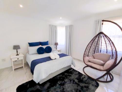 a bedroom with a swing chair and a bed at Greenview Haven in Stompneusbaai