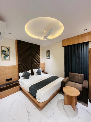 ein Schlafzimmer mit einem großen Bett und einer Couch in der Unterkunft Hotel Pacific Inn in Ahmedabad