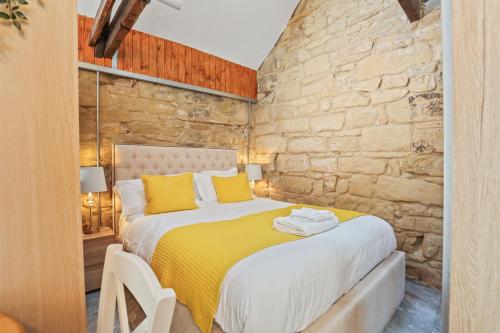 a bedroom with a king sized bed with yellow pillows at The Old Wash House - North East Escapes in Amble