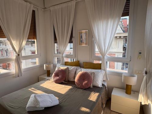 a bedroom with white curtains and a bed with two pillows at Altana Bologna in Bologna