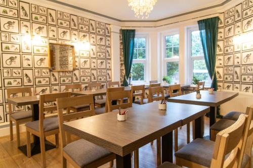 a restaurant with wooden tables and chairs and windows at The Cherry Tree B&B in Eastbourne