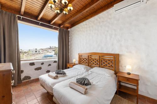 a bedroom with two beds and a large window at Finca Morro Herreno in Las Breñas