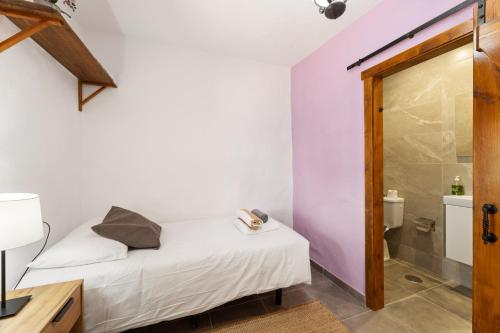 a small bedroom with a bed and a shower at Finca Morro Herreno in Las Breñas